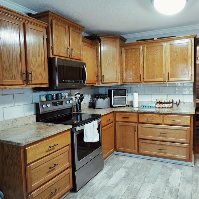 kitchen with light wood-style floors, stainless steel electric range, decorative backsplash, and brown cabinets