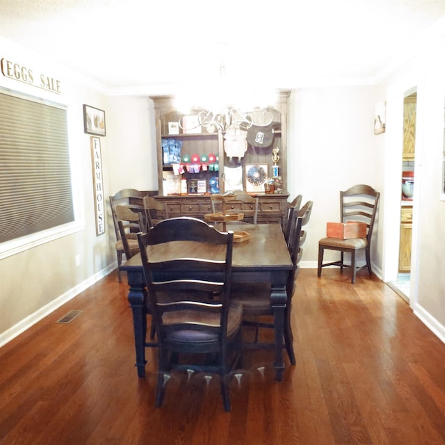 dining space with visible vents, crown molding, baseboards, and wood finished floors