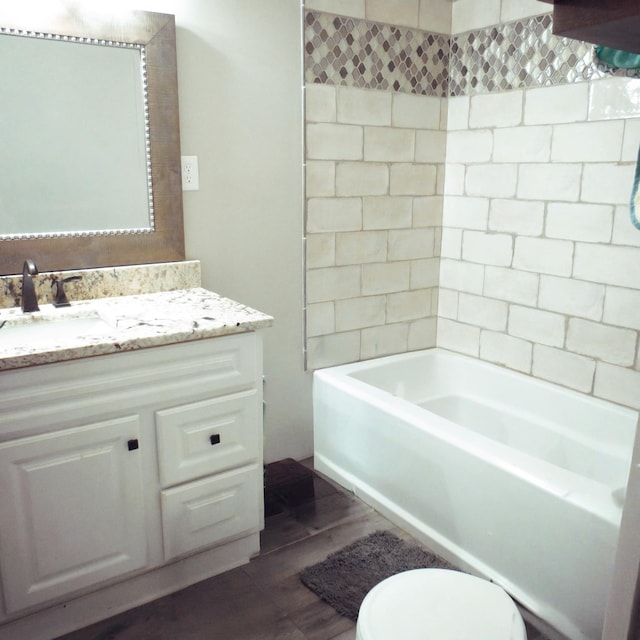 full bath featuring bathtub / shower combination, vanity, toilet, and wood finished floors