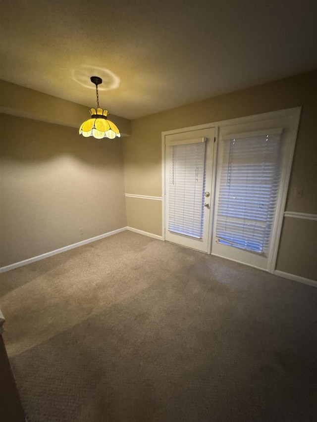 unfurnished room with carpet and baseboards