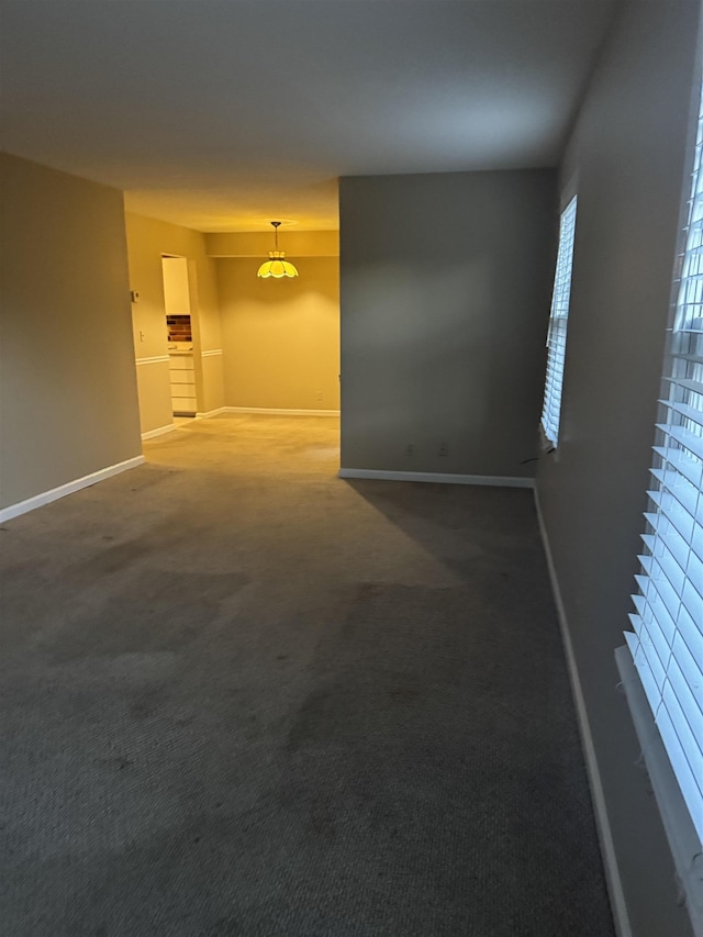 unfurnished room with carpet flooring and baseboards