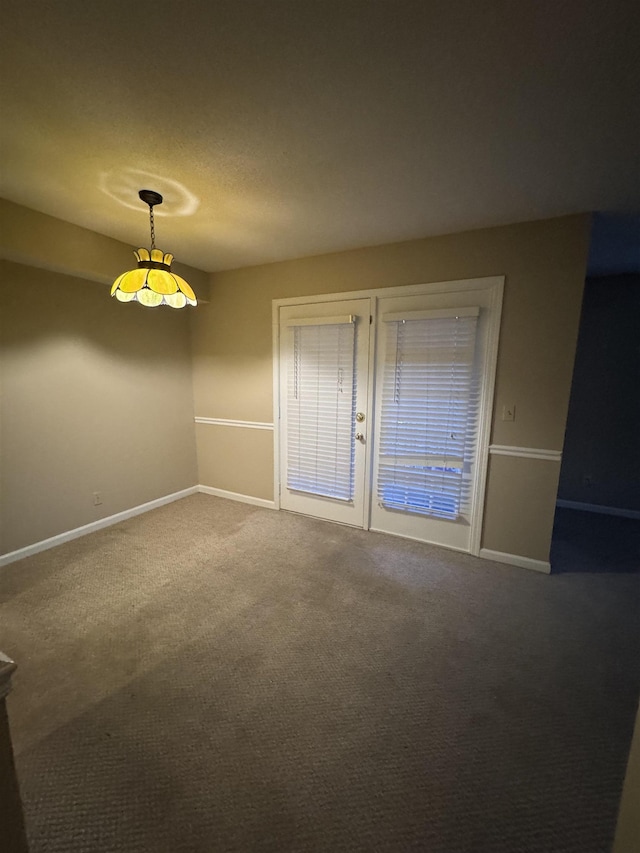 spare room with baseboards and carpet flooring