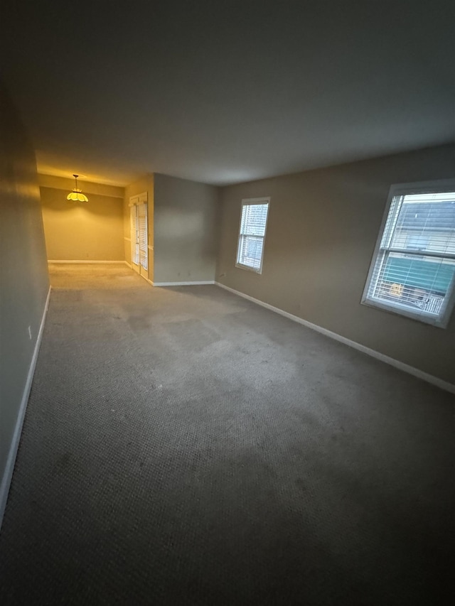 carpeted empty room with baseboards