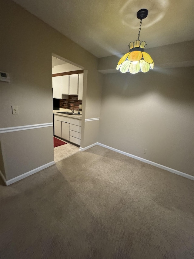 interior space with carpet floors, a sink, and baseboards