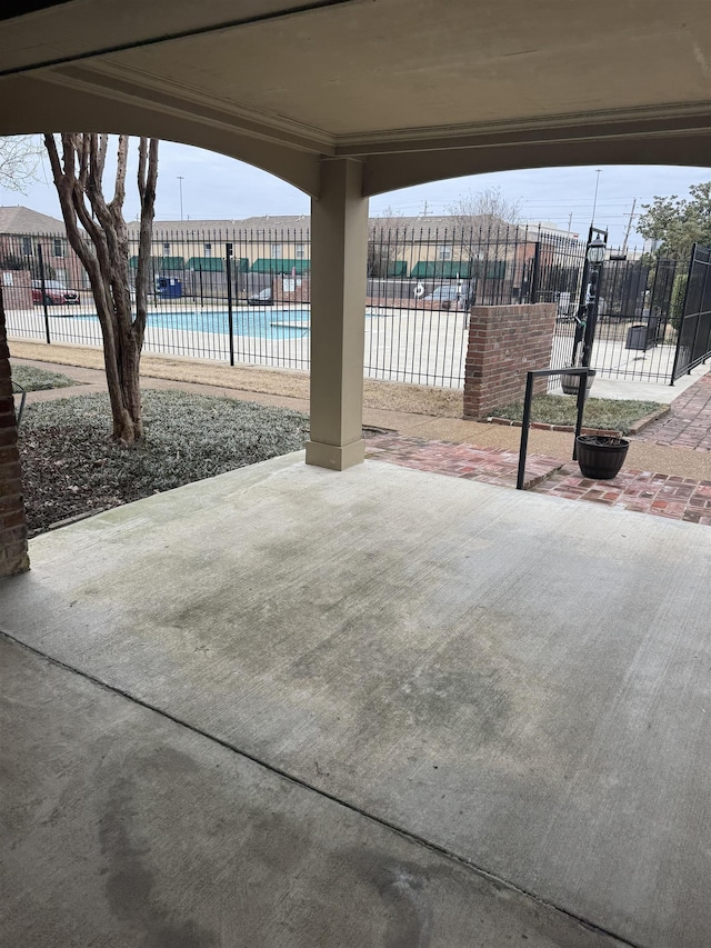 view of patio / terrace with a community pool and fence