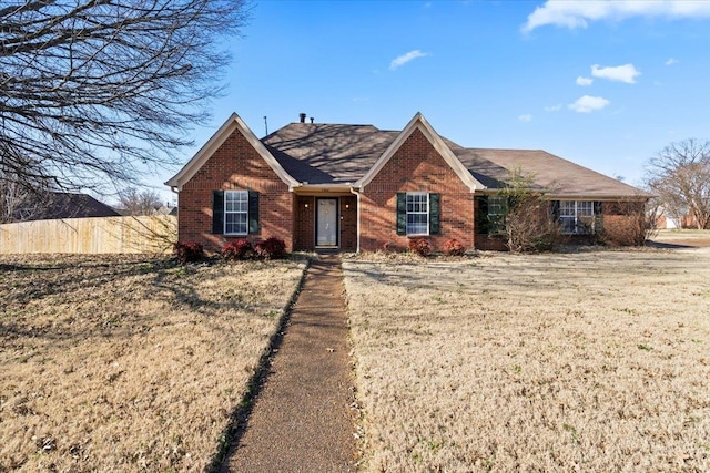 ranch-style home featuring brick siding and a front lawn