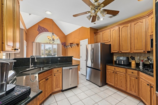 kitchen featuring light tile patterned floors, tasteful backsplash, appliances with stainless steel finishes, vaulted ceiling, and a sink