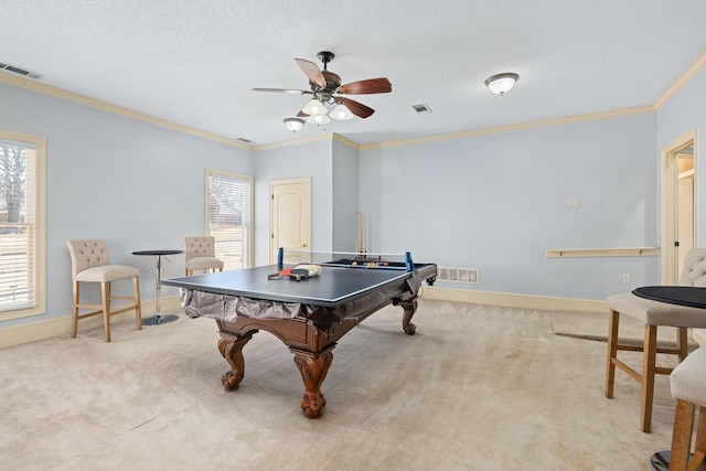 recreation room with carpet, visible vents, crown molding, and a textured ceiling