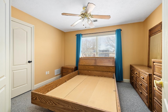 carpeted bedroom with visible vents, ceiling fan, a textured ceiling, and baseboards