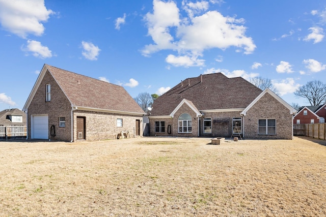 view of front of home featuring a garage, a front yard, brick siding, and fence