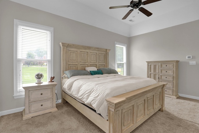 bedroom with light colored carpet, ceiling fan, visible vents, and baseboards