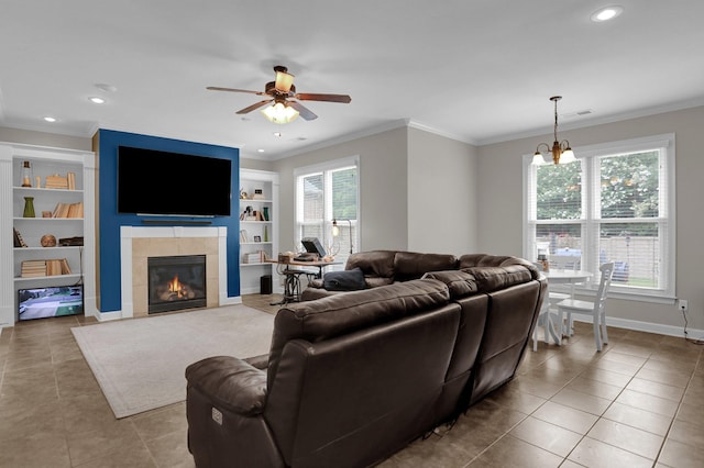 living room featuring ornamental molding, tile patterned flooring, baseboards, and built in shelves