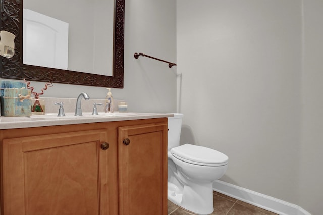 bathroom with baseboards, vanity, toilet, and tile patterned floors