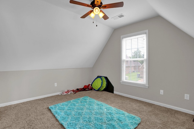 recreation room featuring lofted ceiling, ceiling fan, carpet flooring, visible vents, and baseboards