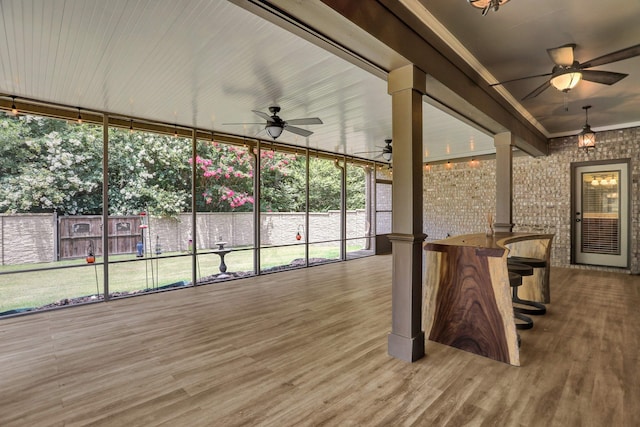 unfurnished sunroom featuring ceiling fan