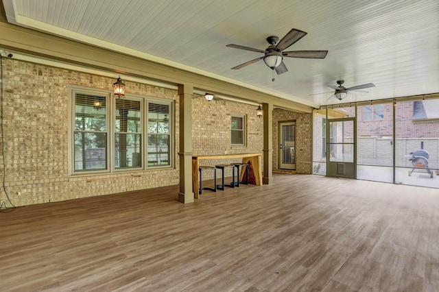 unfurnished sunroom with ceiling fan and plenty of natural light