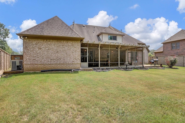 back of house featuring a sunroom, a fenced backyard, and a lawn