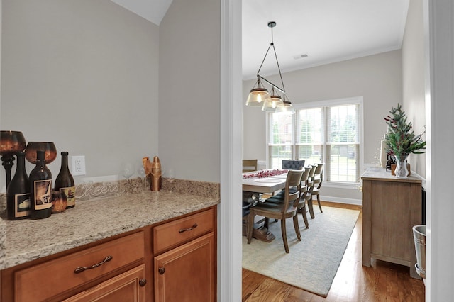 dining area featuring ornamental molding, visible vents, baseboards, and wood finished floors