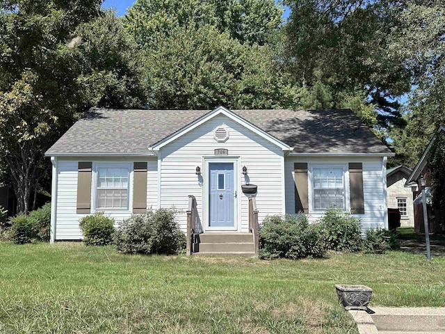 view of front of property with a front lawn and roof with shingles