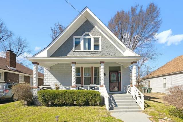 view of front of property with a porch and a front lawn