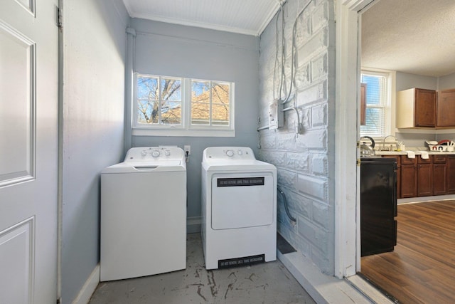 washroom with washing machine and dryer, laundry area, crown molding, and wood finished floors