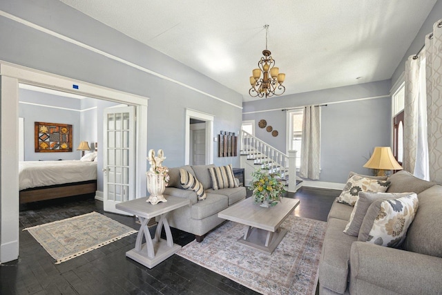 living room with an inviting chandelier, wood-type flooring, stairway, and baseboards