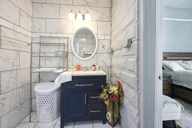 ensuite bathroom with marble finish floor, vanity, and ensuite bathroom