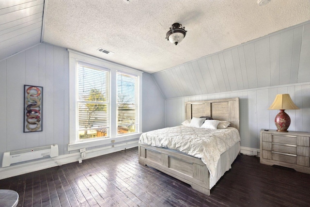 bedroom with dark wood-style floors, visible vents, vaulted ceiling, and a textured ceiling