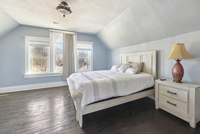 bedroom with dark wood-style floors, baseboards, visible vents, and a textured ceiling