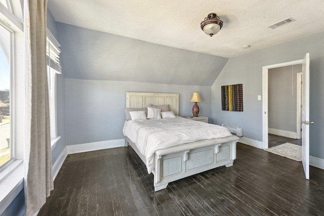 bedroom featuring lofted ceiling, multiple windows, and baseboards