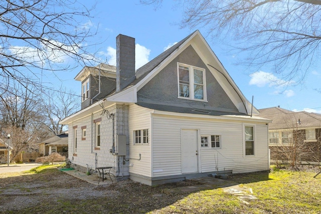 back of house featuring a chimney