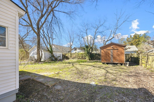 view of yard featuring an outbuilding, a fenced backyard, and a storage shed