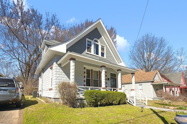 view of front of home with covered porch, central AC unit, and a front yard