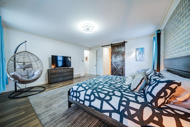 bedroom featuring a barn door, wood finished floors, and crown molding