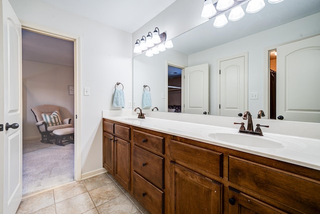 bathroom featuring double vanity, tile patterned flooring, a sink, and baseboards