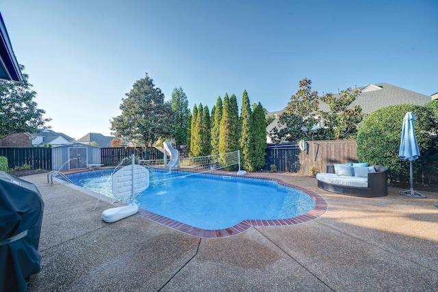 view of swimming pool featuring a water slide, a fenced backyard, a storage shed, a fenced in pool, and a patio area