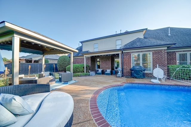 rear view of property featuring a fenced in pool, brick siding, a patio, fence, and an outdoor living space