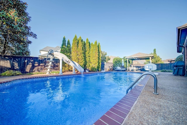 view of pool with a fenced in pool, a water slide, fence, and a gazebo