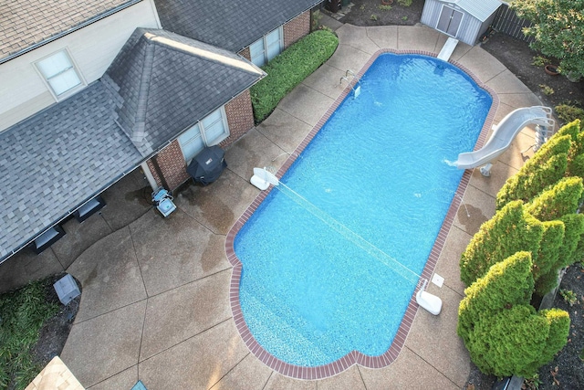 view of pool with a fenced in pool, an outbuilding, a patio, a water slide, and a fenced backyard