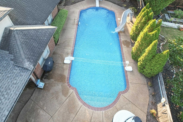 outdoor pool featuring a diving board and a water slide