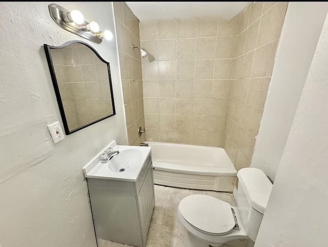 full bathroom with a textured wall, vanity, and toilet