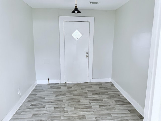 interior space featuring baseboards, visible vents, and light wood-style flooring