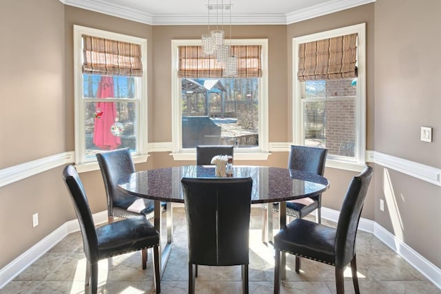 dining room featuring baseboards, ornamental molding, and a healthy amount of sunlight