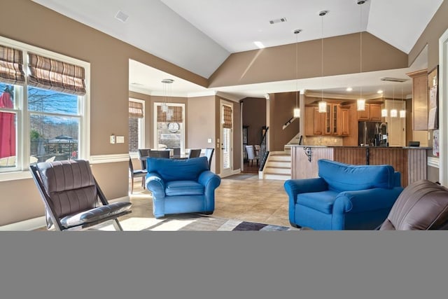 living area with stairs, vaulted ceiling, visible vents, and baseboards