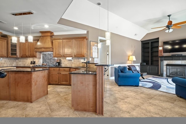 kitchen featuring open floor plan, custom range hood, a sink, and a peninsula