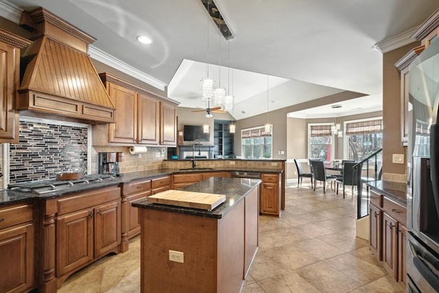 kitchen with a kitchen island, a peninsula, premium range hood, stainless steel gas cooktop, and a sink