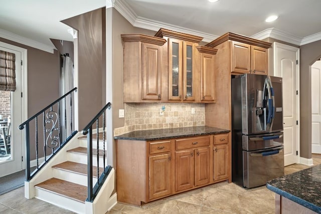 kitchen featuring ornamental molding, glass insert cabinets, stainless steel refrigerator with ice dispenser, and dark stone countertops