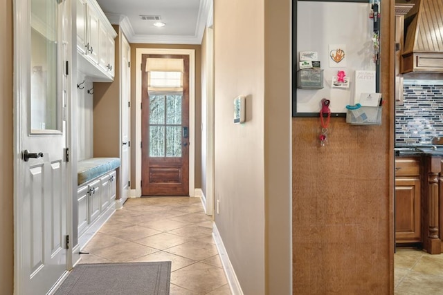 mudroom with light tile patterned flooring, baseboards, visible vents, and ornamental molding