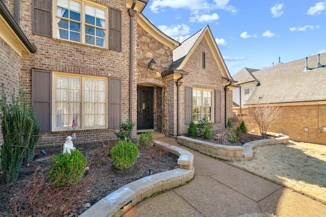 view of exterior entry featuring brick siding