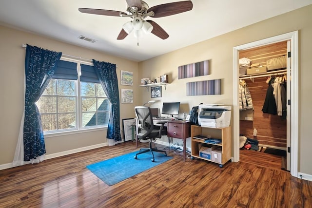 home office with a ceiling fan, visible vents, baseboards, and wood finished floors